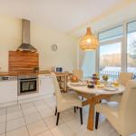 Küche mit Essbereich und Balkonansicht.