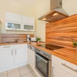 Moderne Küche mit Holzoberflächen und Edelstahlgeräten.