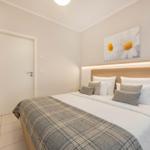 Schlafzimmer mit Bett, Wandbild und Nachttisch