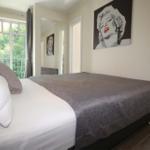 Schlafzimmer mit Bett, Wandbild und Balkonansicht