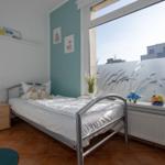 Ein Schlafzimmer mit Bett, Nachttisch und Fenster mit Blick.