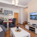 Wohn- und Essbereich mit Küche, Fernseher und Couch.