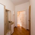 Flur mit Kleiderschrank, Spiegel und Tür zum Treppenhaus.
