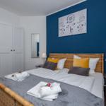 Schlafzimmer mit Bett, Nachttischen und Wandbild