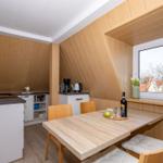 Küche mit Essplatz unter Dachschräge, Holzwand, Fenster mit Blick.