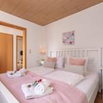 Schlafzimmer mit Bett, Nachttisch und Bild an der Wand.