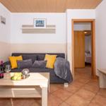 Wohnzimmer mit Sofa, Couchtisch und Blick in Schlafzimmer