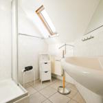 Badezimmer mit Dusche, Waschbecken und Dachfenster