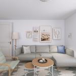 Wohnzimmer mit Sofa, Sessel und Meerblick durch große Glastür.