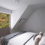 Schlafzimmer mit Dachschrägen, großem Fenster und Bett mit Kissen.