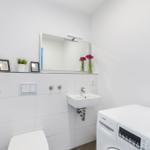 Badezimmer mit Toilette, Waschbecken und Waschmaschine.