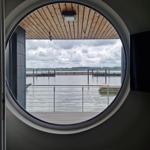 Rundes Fenster mit Blick auf Wasser und Steg