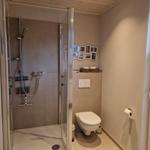 Bad mit Dusche, Toilette und Fenster mit Jalousie.