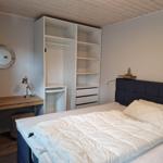 Schlafzimmer mit Bett, Kleiderschrank und Schreibtisch.