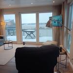 Wohnzimmer mit Blick auf den Hafen und Terrasse mit Tisch.