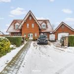Rotes Backsteinhaus mit Schneebedecktem Dach und Garage