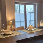 Esstisch mit Platz für zwei, Blick auf Balkon und Wohnbereich