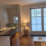 Wohnbereich mit Kücheninsel, Sofa und Fenster zur Aussicht.