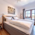 Schlafzimmer mit Doppelbett, Holzboden und Fenster mit Blick.