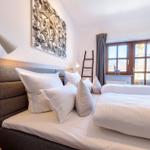 Schlafzimmer mit Bett, Fenster und Wandbild.