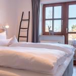 Ein Schlafzimmer mit Doppelbett, Fenster und dekorativen Elementen.