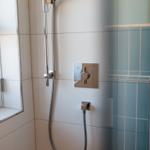 Duschkabine mit Glaswand, Duschbrause und Fenster
