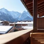 Balkon mit Blick auf schneebedeckte Berge und Dächer