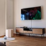 Wohnzimmer mit Fernseher, Holzboden und modernem Sideboard.