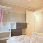 Schlafzimmer mit Bett, Kleiderschrank und Tür