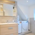Badezimmer mit Waschmaschine und Spiegelschrank