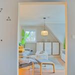 Durchgang in Wohnbereich mit Sofa, Tisch und Deckenfenster