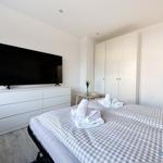 Schlafzimmer mit Bett, Fernseher und Kleiderschrank.