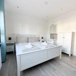 Schlafzimmer mit Doppelbett, Schrank und Fenster