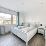 Schlafzimmer mit Doppelbett, Nachttischen und Fenster mit Blick.