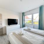 Schlafzimmer mit Doppelbett, TV und Fenster mit Blick.