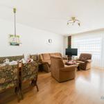 Wohn- und Essbereich mit Sofa, Sesseln und Esstisch.