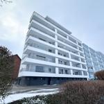 Modernes Mehrfamilienhaus mit Balkonen und Schneebedecktem Boden.