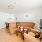 Wohn- und Essbereich mit Sofa, Sessel und Esstisch.