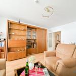 Wohnzimmer mit Holzmöbeln, Sitzgelegenheiten und Tisch mit Getränken.