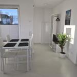 Esszimmer mit Tisch, Stühlen und Pflanze. Fenster mit Jalousie. Kleiderschrank und Wandbild.