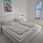 Schlafzimmer mit Doppelbett, Nachttischen und Fenster