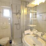 Badezimmer mit Dusche, Waschbecken und Toilette.