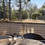Terrasse mit Tisch, Stühlen und Blick auf Wald.
