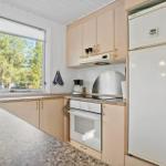Küche mit Kühlschrank, Herd und Fenster zum Garten