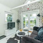 Wohnzimmer mit Sofa, Fernseher und Terrassentür.