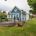 Blau-weißes Ferienhaus mit Terrasse, Grill und Garten.