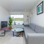 Wohnzimmer mit Sofa, Fernseher und Blick auf Wasser