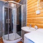 Badezimmer mit Dusche, Waschbecken und Waschmaschine.