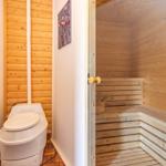 Sauna mit Holzbank und Toilette in angrenzender Wand