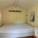 Schlafzimmer mit Bett, Fenster und Wandbild.